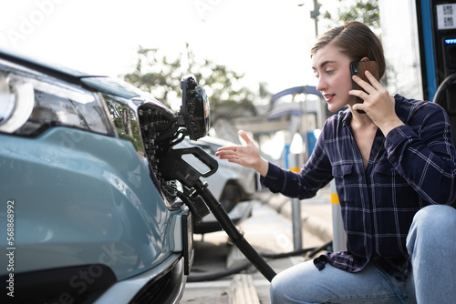 Woman call mobile phone about Accident and breakdowns with EV Charger at station. Broken down car, blonde woman having problem, calling to somebody for help.