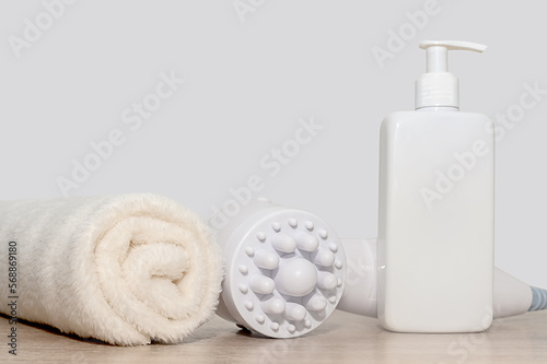 White massager towel and dispenser. On a wooden surface. Therapeutic massage.