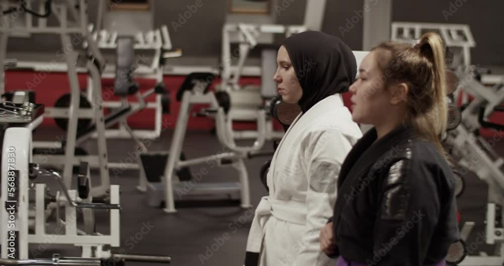 Female wrestlers walking and talking in gym Female wrestlers walking and talking in gym
