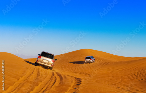 Offroad safari in sand desert, Empty Quarter Desert in United Arab Emirates. Offroaders on dunes in Rub’ al Khali desert. Sand and sky.