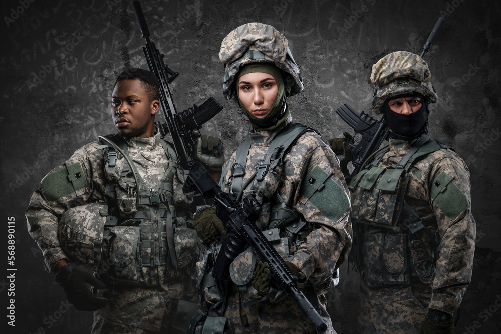 Fototapeta premium Portrait of three soldiers dressed in camouflage uniform holding rifles.