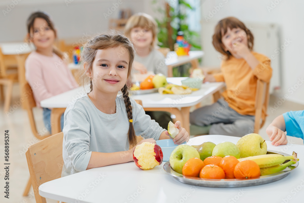 Children eating a fruit snack in a kindergarten 