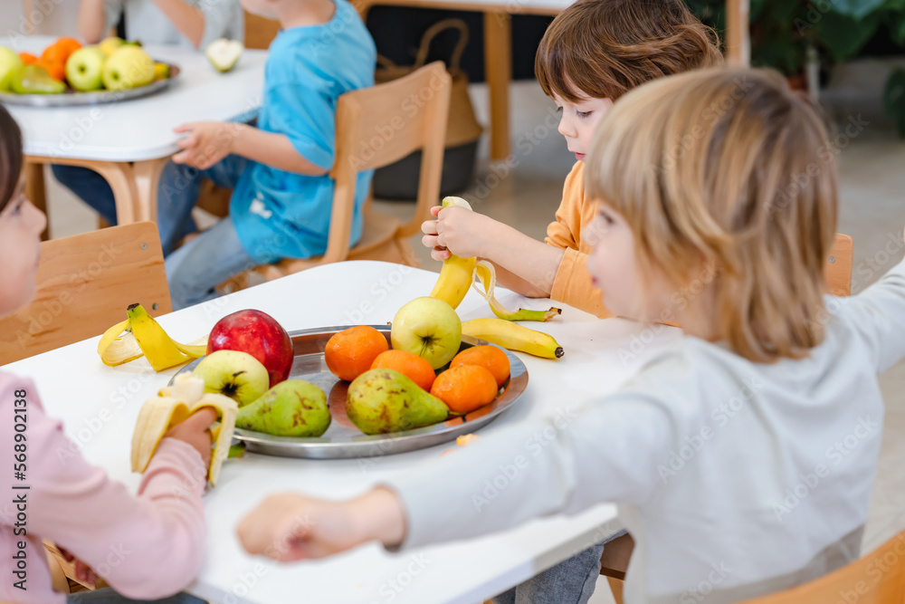 Children eating a fruit snack in a kindergarten Children eating a fruit snack in a kindergarten