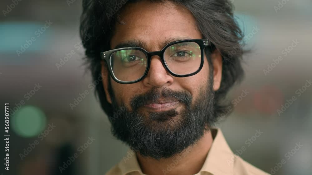 Close up front view Arabic handsome bearded man agent worker guy in glasses Indian company CEO calm businessman in eyeglasses looking at camera posing in office. Male client of ophthalmology service Close up front view Arabic handsome bearded man agent worker guy in glasses Indian company CEO calm businessman in eyeglasses looking at camera posing in office. Male client of ophthalmology service