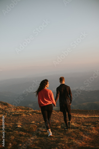 Smiling couple walking over green hills © BGStock72