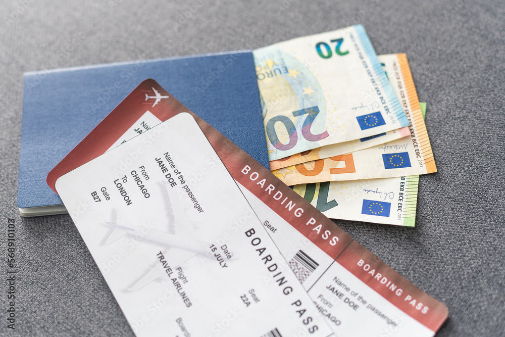 Fototapeta premium Two blue passports, green boarding pass, flight tickets gray background close up top view, airplane travel, passengers check in, customs control, border cross, holidays, vacation, tourism.