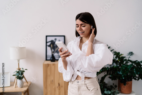 Cheerful woman with smartphone talking on smartphone
