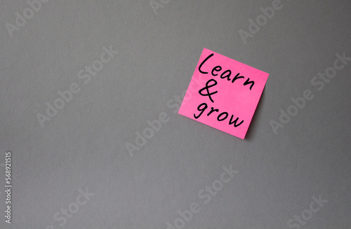 Learn and grow symbol. Concept words Learn and grow on pink steaky note. Beautiful grey background. Business and Learn and grow concept. Copy space. photo