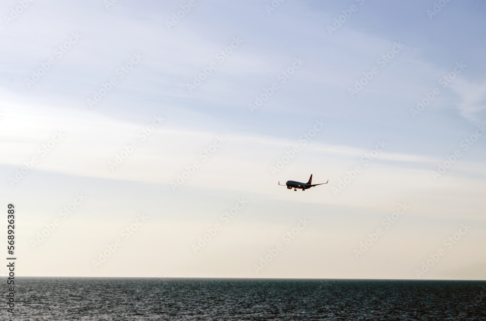 Passenger plane flying low over the sea, landing