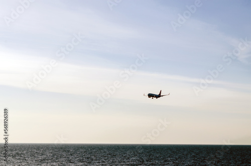 Passenger plane flying low over the sea, landing