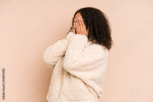 Young african american curly woman isolated afraid covering eyes with hands. © Asier