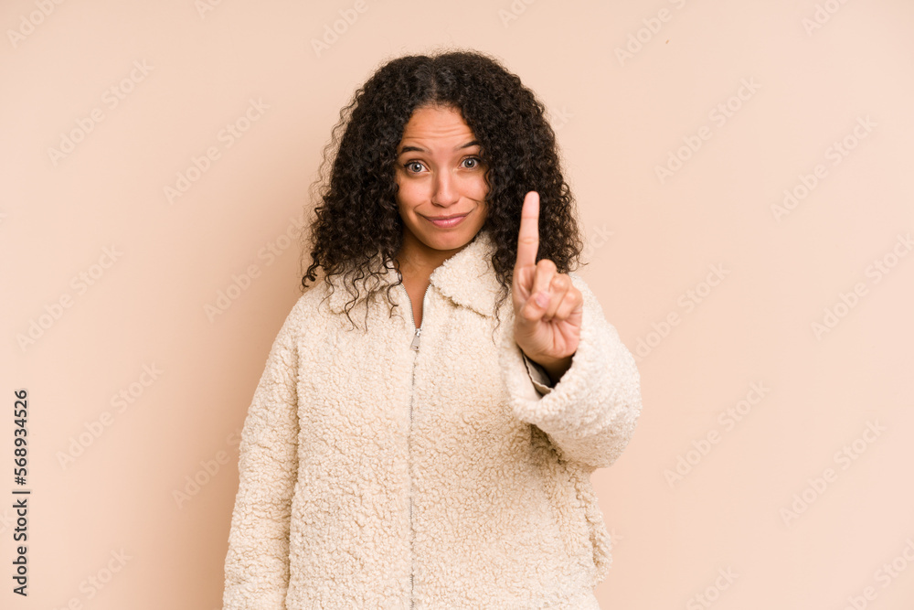 Young african american curly woman isolated showing number one with finger. Young african american curly woman isolated showing number one with finger.