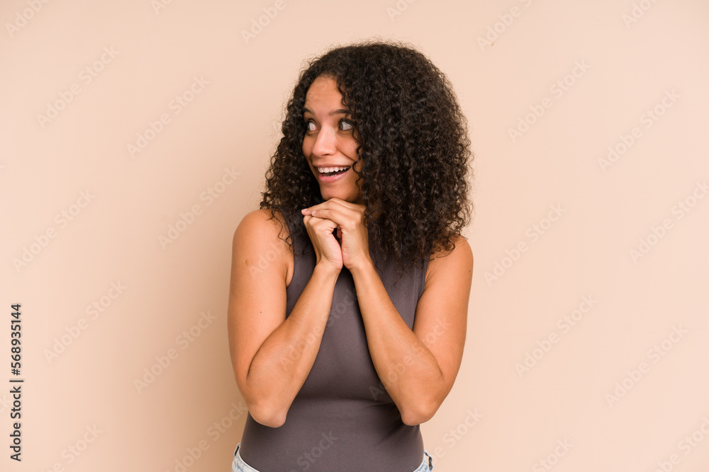 Young african american curly woman isolated praying for luck, amazed and opening mouth looking to front. Young african american curly woman isolated praying for luck, amazed and opening mouth looking to front.