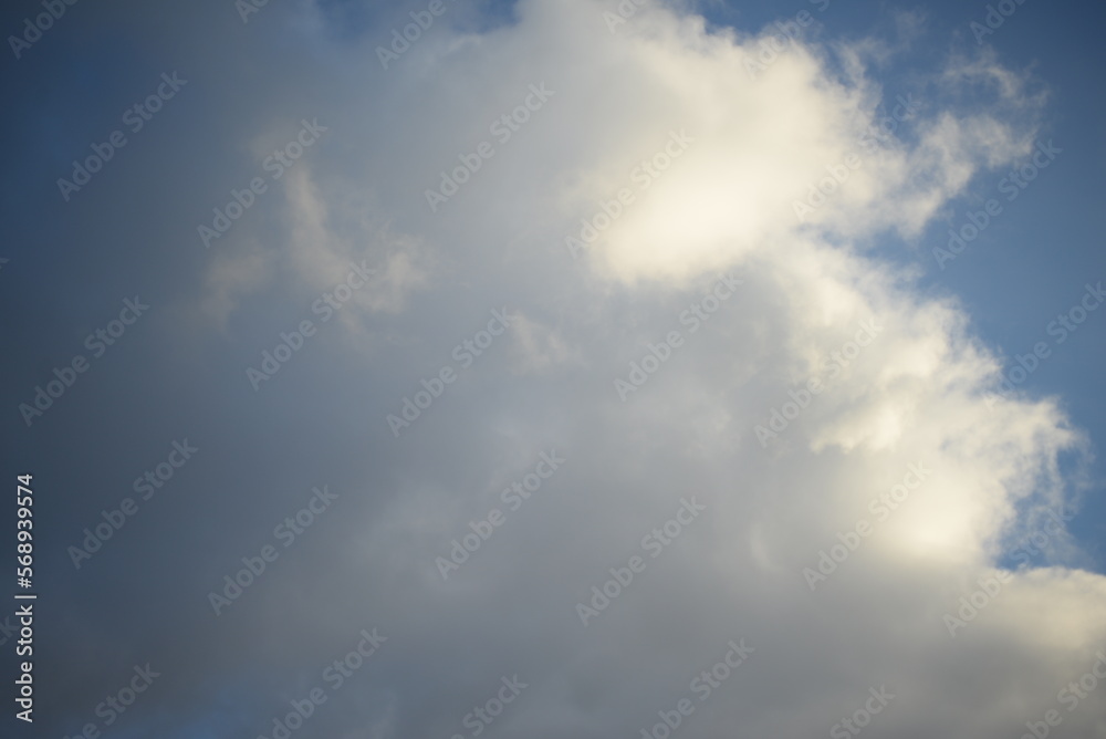 rays of the sun through the cirrus clouds against the blue sky, white rainy clouds blue sky illuminated by the rays of the sun, one small cirrus cloud blurred clouds background rays of the sun through the cirrus clouds against the blue sky, white rainy clouds blue sky illuminated by the rays of the sun, one small cirrus cloud blurred clouds background