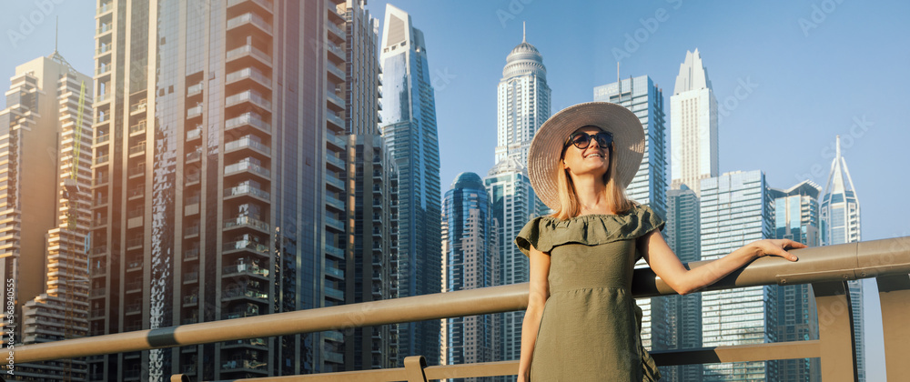 Φωτογραφία fashion woman in green dress and hat enjoying Dubai city architecture