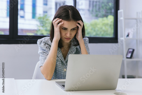 Business woman working on laptop computer in modern home office. Woman Serious working on laptop. Serious mature older adult woman watching on laptop working from home.
