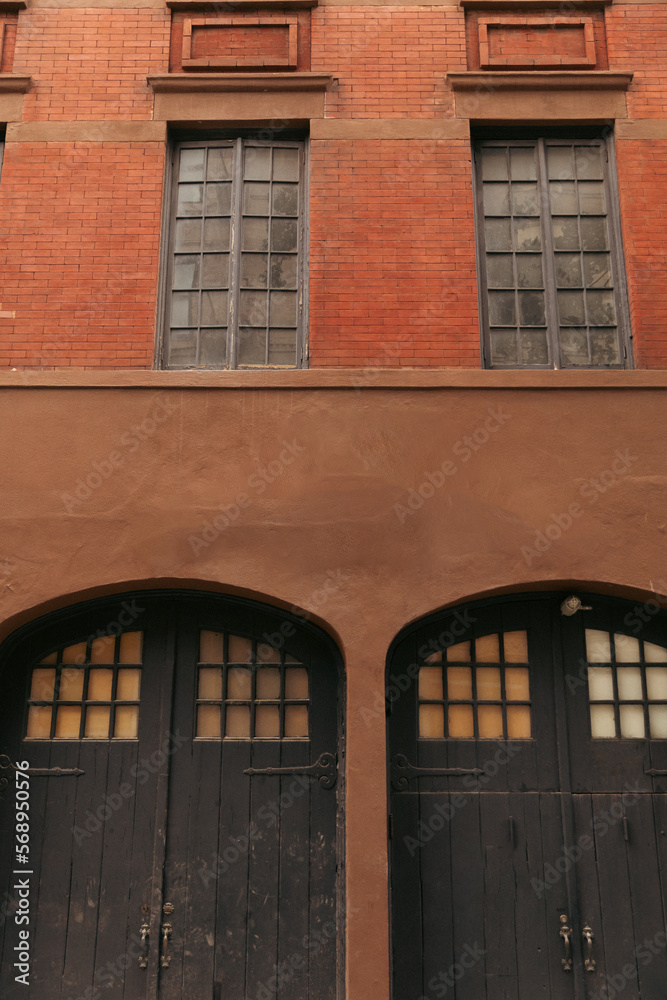 Wooden doors on facade of brick building on street in New York City.