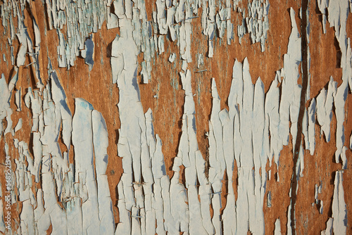 Peeled off paint on rusty vehicle surface of a ruined train. Vintage metal background with wheathered rotten color and massive corrosion in shades of blue, brown and turqouise with selective focus. photo