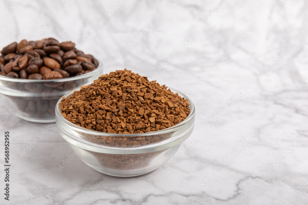 Coffee granules and coffee beans on a white marble background. Instant coffee drink. Energy hot drink. Place for text. Place for copy. Cheerful morning concept. Coffee granules and coffee beans on a white marble background. Instant coffee drink. Energy hot drink. Place for text. Place for copy. Cheerful morning concept.