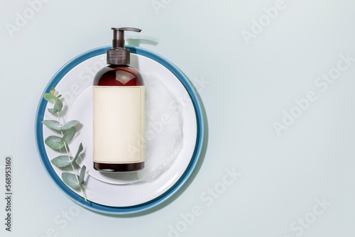 Wallpaper Mural Mockup of dish detergent. Eco friendly natural cleaning dishes. Bottle with dish detergent on a plates with sprig of eucalyptus on blue background. Flat lay, copy space Torontodigital.ca