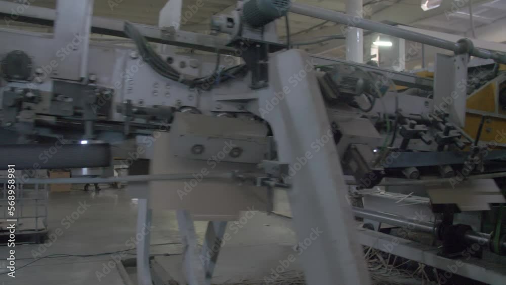 Conveyor line for the production of cardboard boxes. Finished boxes move through the finished product shop on a conveyor belt Conveyor line for the production of cardboard boxes. Finished boxes move through the finished product shop on a conveyor belt