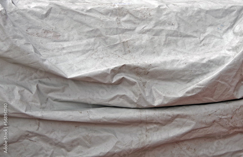 Dirty white weather protection tarpulin outdoors photo