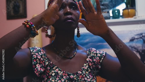Black Stock Footage of calm, meditative, and spiritual elderly Black senior woman in her holistic and zen home filled with African art