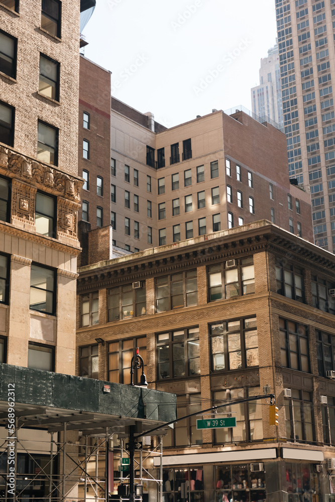 different stone and concrete buildings on urban street in New York City.