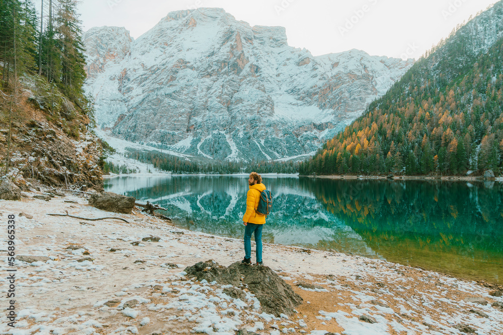 Man near Lago di Braies in winter Man near Lago di Braies in winter