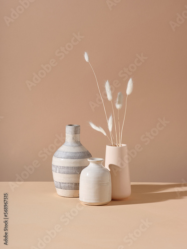 A bunch of dried bunnytail flower in a white ceramic vase photo