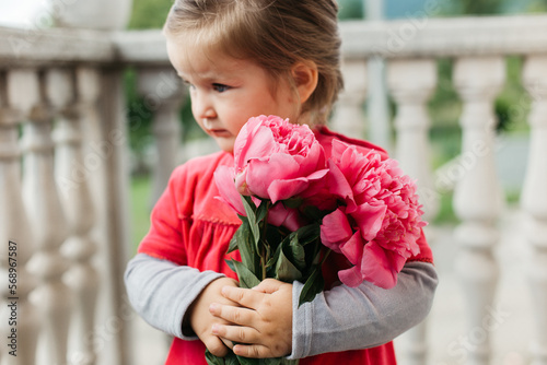 Little girl holding bouquet of peonies   photo