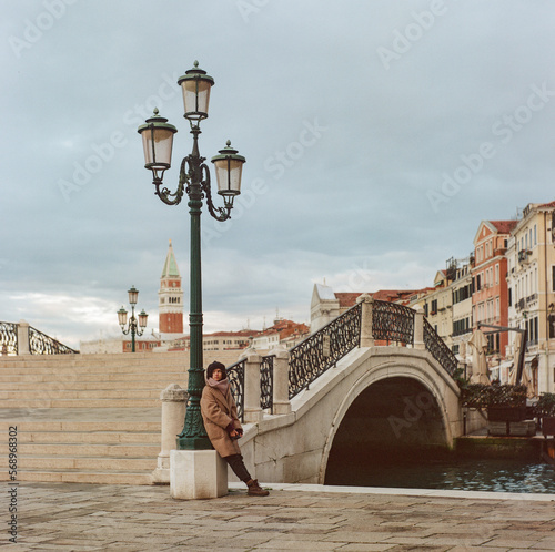 A young woman in an overcoat walks the deserted streets of Venice photo