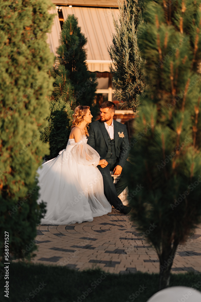 the bride and groom on a park bench. 