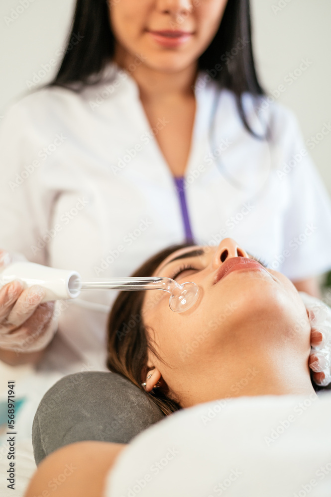 Faceless specialist doing darsonvalization Faceless specialist doing darsonvalization