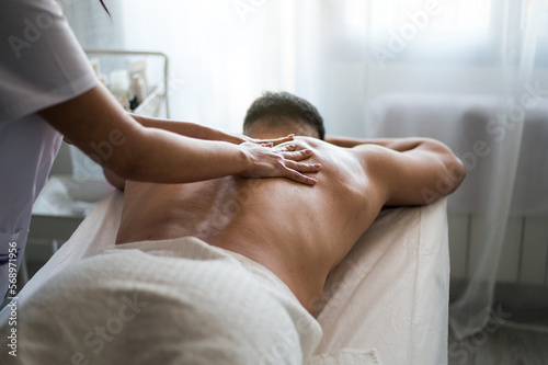 Masseuse massaging client in spa salon photo