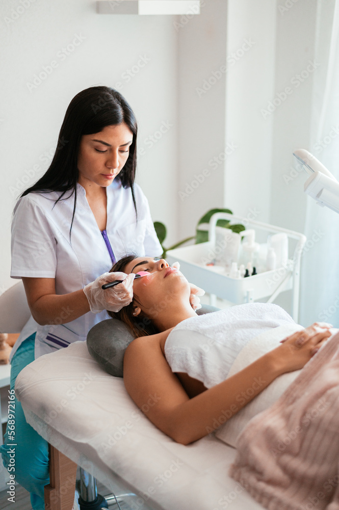 Female cosmetologist doing procedure for client Female cosmetologist doing procedure for client