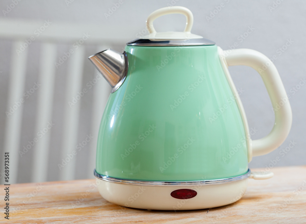Turquoise electric tea kettle on wooden table, water boiler and heater  Stock Photo | Adobe Stock