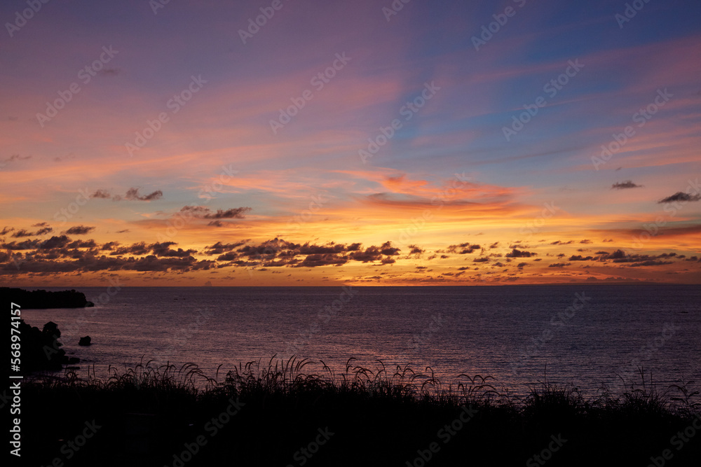 Beautiful sunset view in Bali with reed grass in the foreground Beautiful sunset view in Bali with reed grass in the foreground