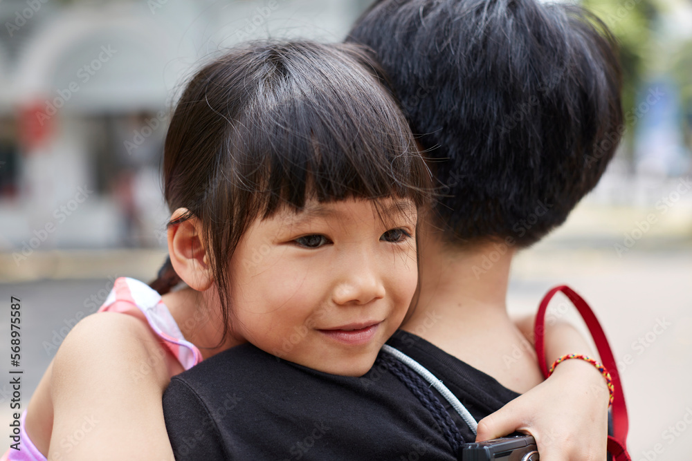Asian little girl snuggling on mother's shoulder Asian little girl snuggling on mother's shoulder