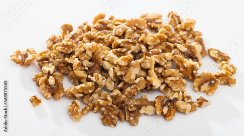 Pile of raw shelled walnut kernels on white surface. Healthy and nutritious snack