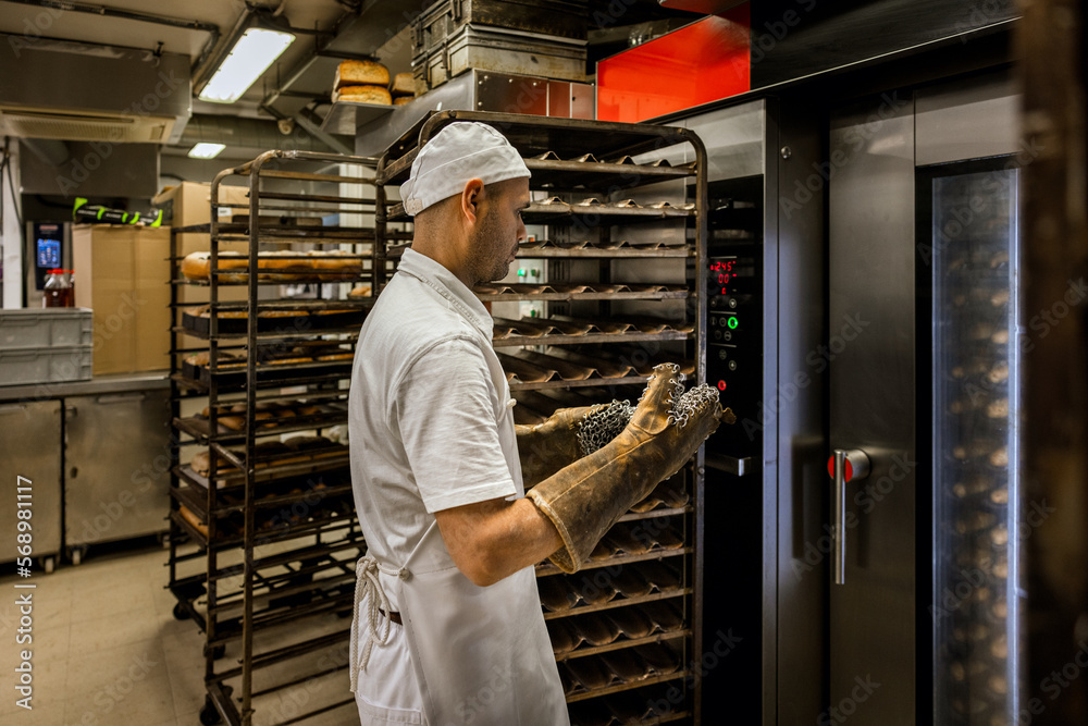 Man taking buns out of oven Man taking buns out of oven