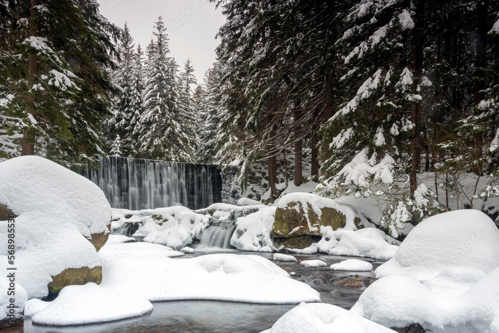 A wild waterfall in Karpacz in the Karkonosze Mountains. Winter landscape of a waterfall in the mountains. A wild waterfall in Karpacz in the Karkonosze Mountains. Winter landscape of a waterfall in the mountains.