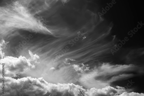White clouds on a dark dramatic sky. Storm wind clouds. Black and white sky template