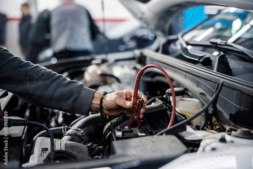 Cropped picture of a mechanic doing car battery diagnostics.