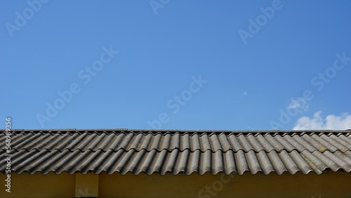 metal roof of industrial warehouse against sky © Esteve