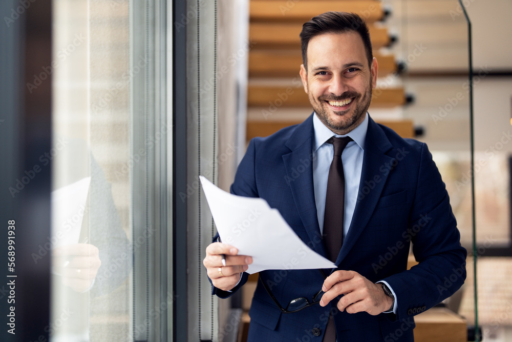 Handsome well dressed businessman holding documents Handsome well dressed businessman holding documents