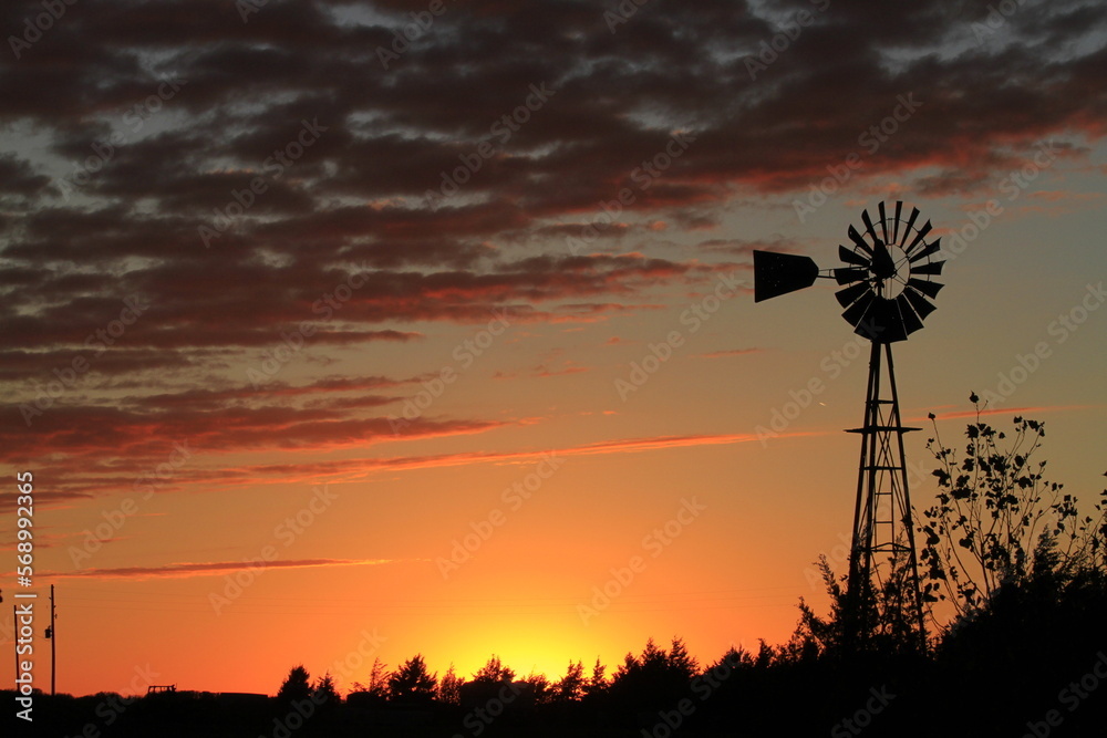 Sunset with clouds and farm Windmill silhouette in the country. Sunset with clouds and farm Windmill silhouette in the country.