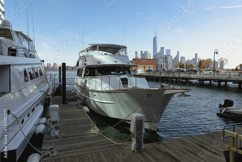 white yachts near pier on Hudson river with New York cityscape on background.