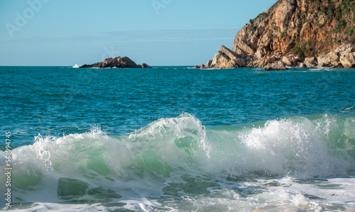 A transparent wave of the turquoise sea rolls onto the shore