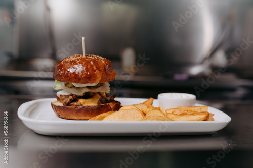 A big tasty burger and fries on a metal table background
